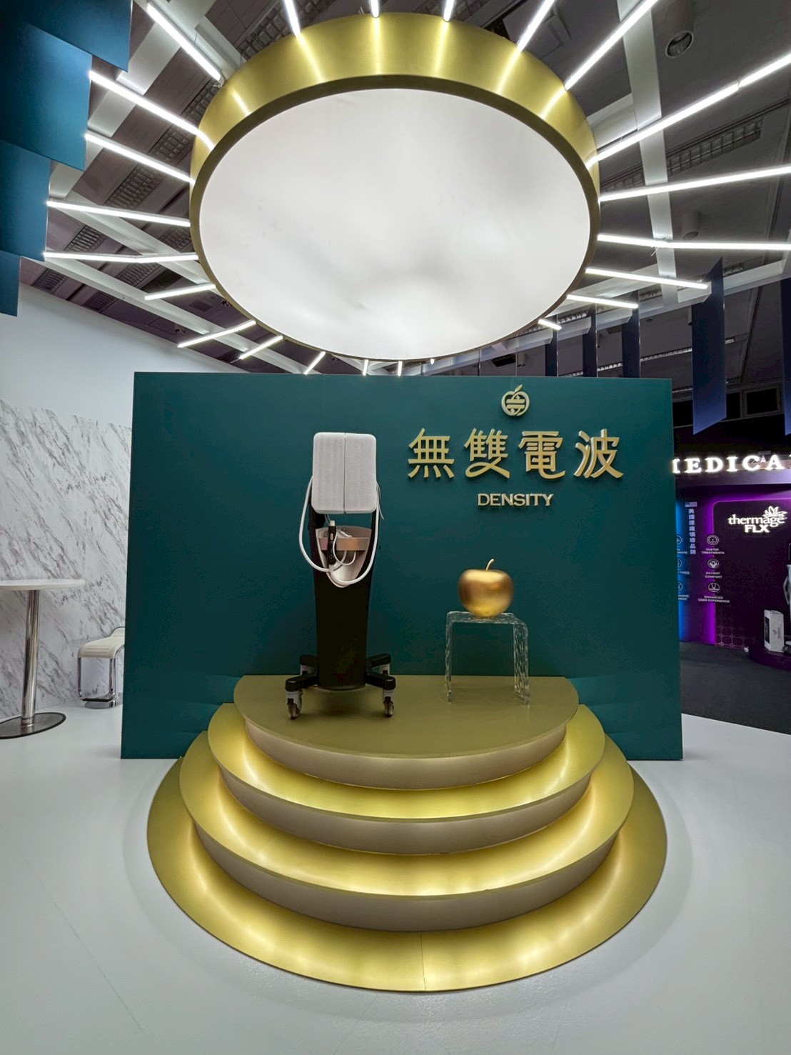 醫美儀器精品級展台設計_無雙電波DENSITY金色環形光帶天花與階梯式台座，提升醫療器材展覽陳列質感