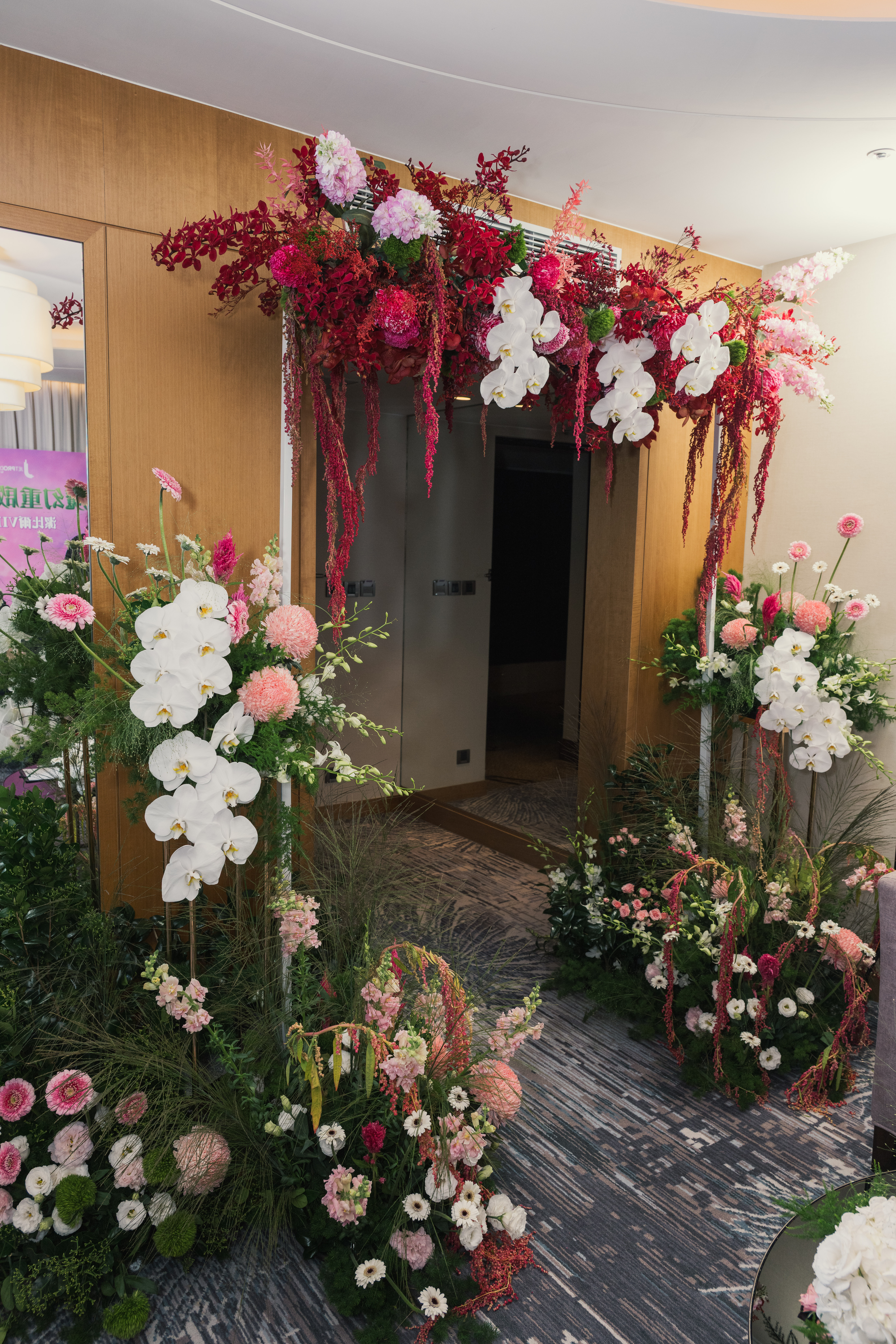 VIP體驗會花藝佈置_入口花藝拱門裝飾，大量鮮花與綠葉營造Wicked奇幻森林氛圍